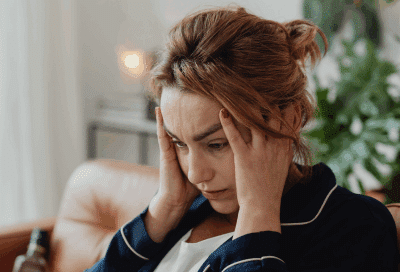 A woman holding her head, representing coping with a cancer diagnosis