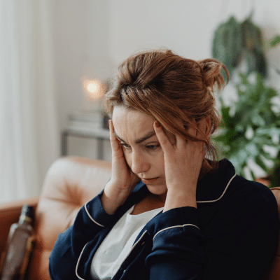 A woman holding her head, representing coping with a cancer diagnosis