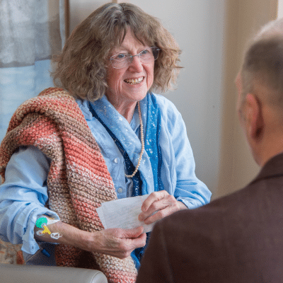 Older female patient holding paper, engaged in conversation with dr. Charles l. Maurer is a board certified medical oncologist and hematologist from hematology oncology associates of fredericksburg, representing understanding blood test results